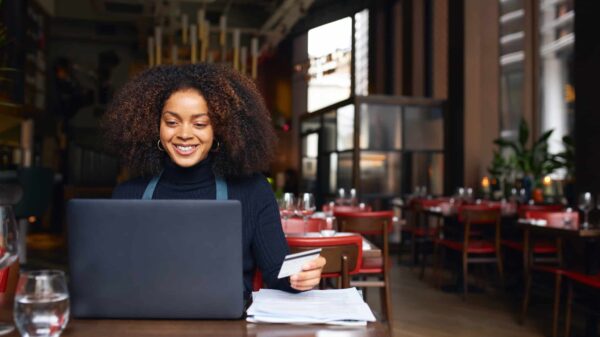 A worker uses a laptop inside a restaurant.